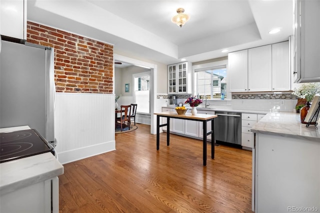 7996 Bradburn Blvd, Westminster, CO 80030 - kitchen featuring dishwasher, wainscoting, white cabinets, light wood-style floors, and a sink