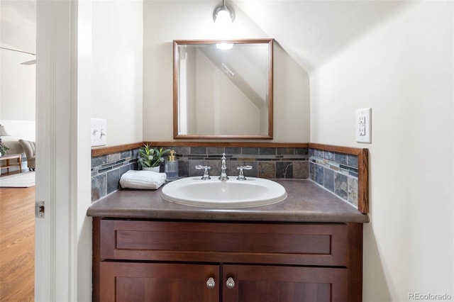 7996 Bradburn Blvd, Westminster, CO 80030 - bathroom with vanity, vaulted ceiling, backsplash, and wood finished floors