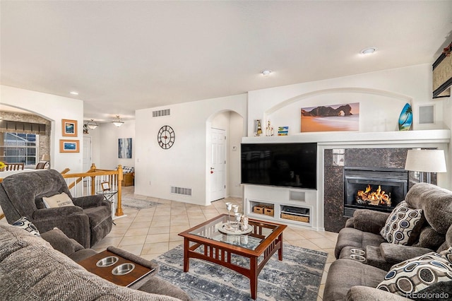 tiled living room featuring a premium fireplace