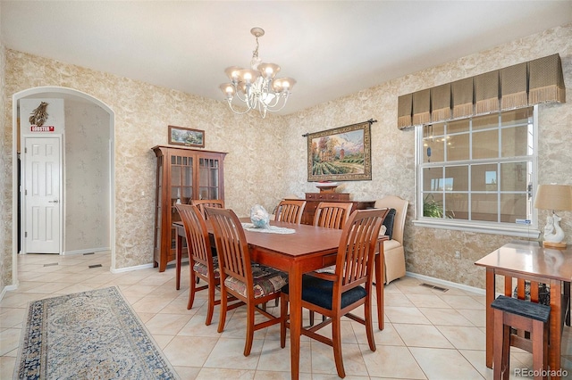 tiled dining space featuring an inviting chandelier