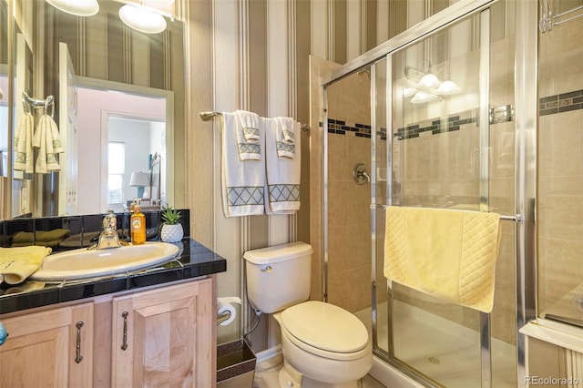 bathroom featuring toilet, an enclosed shower, and vanity