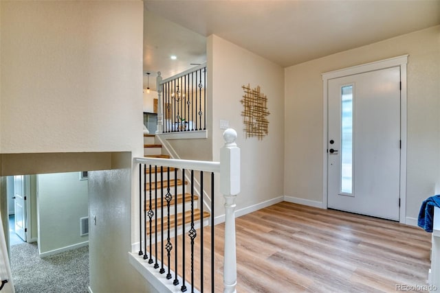 foyer with visible vents, baseboards, and wood finished floors