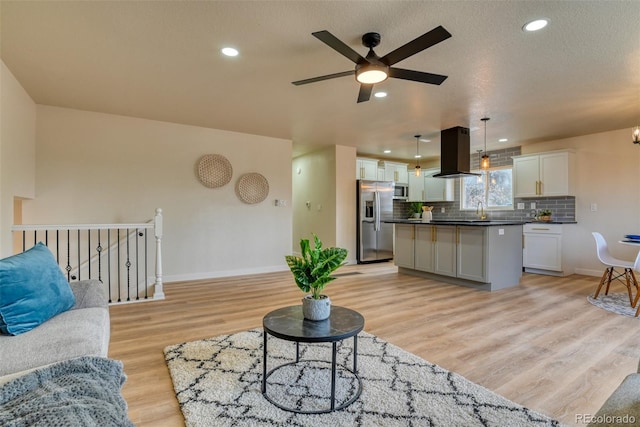 living room featuring recessed lighting, light wood-style floors, and baseboards