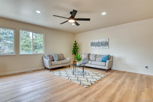 living area featuring a ceiling fan, wood finished floors, visible vents, recessed lighting, and a textured ceiling