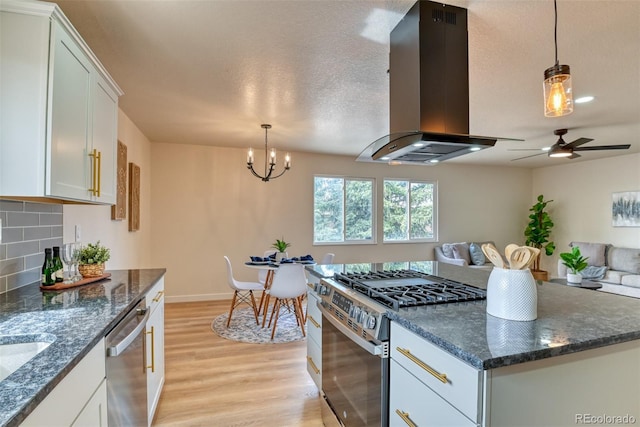 kitchen featuring range hood, white cabinetry, stainless steel appliances, light wood finished floors, and decorative backsplash