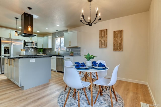 kitchen featuring dark countertops, light wood-type flooring, backsplash, and appliances with stainless steel finishes