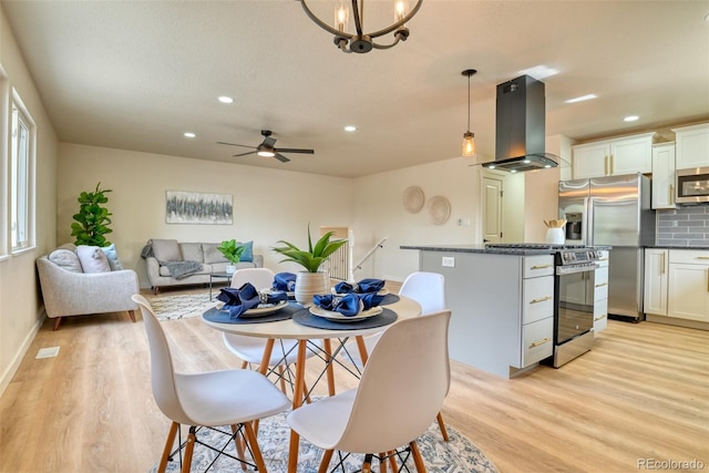 dining area featuring visible vents, light wood-style flooring, ceiling fan with notable chandelier, recessed lighting, and baseboards