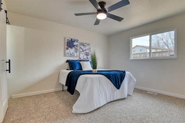 carpeted bedroom with visible vents, ceiling fan, and baseboards