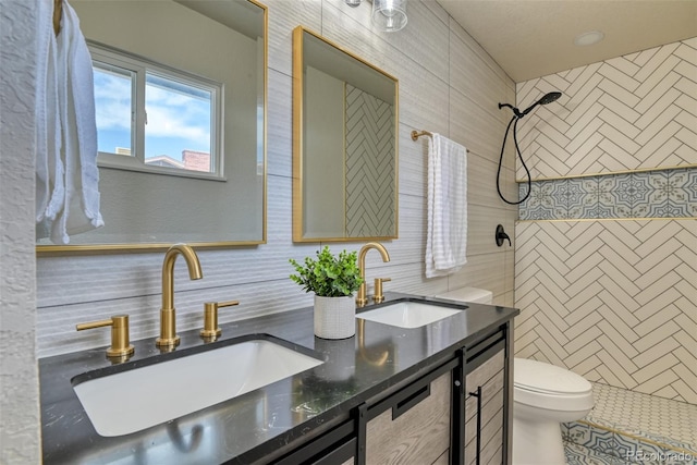 full bath featuring a sink, tiled shower, toilet, and tile walls