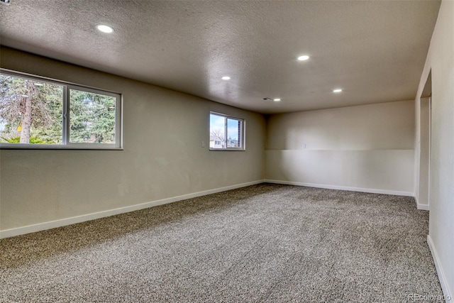 carpeted spare room featuring recessed lighting, baseboards, and a textured ceiling