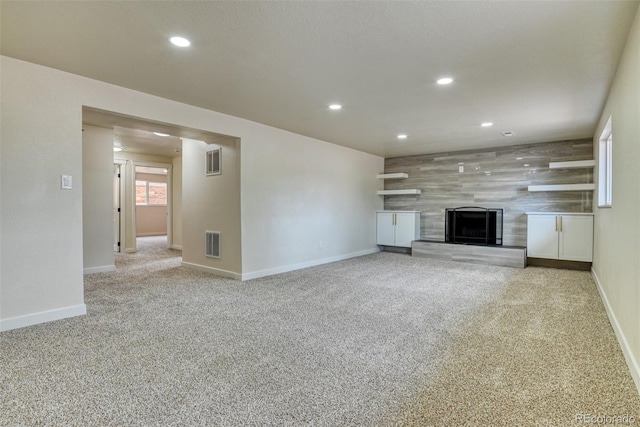 unfurnished living room with recessed lighting, visible vents, carpet floors, and a tiled fireplace