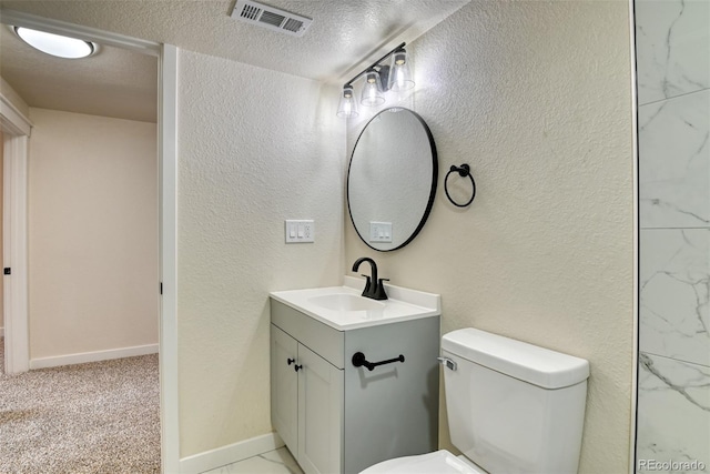 bathroom with visible vents, a textured ceiling, and a textured wall