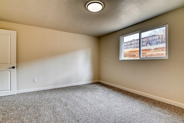 carpeted empty room featuring baseboards and a textured ceiling