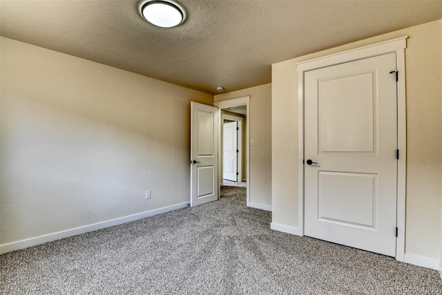 unfurnished bedroom with a textured ceiling, baseboards, and carpet floors