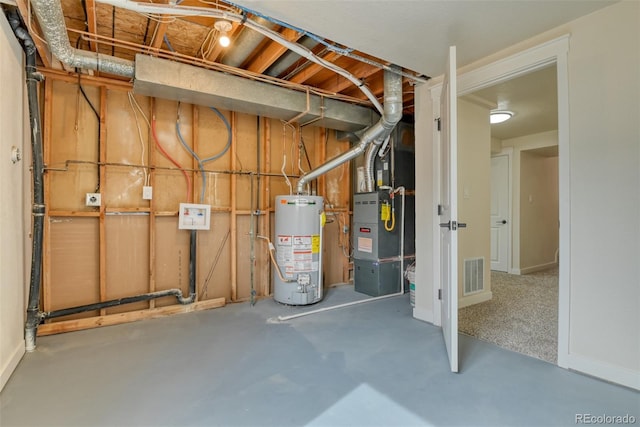 unfinished below grade area featuring water heater, visible vents, and heating unit