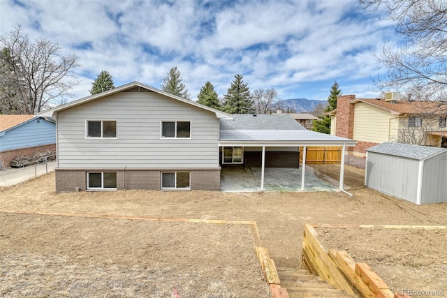 back of house featuring a storage unit, an outdoor structure, and fence