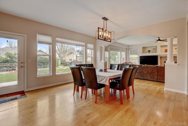 17613 E Peakview Ave, Aurora, CO 80016 - dining space featuring light wood-style flooring, ornate columns, baseboards, ceiling fan, and arched walkways
