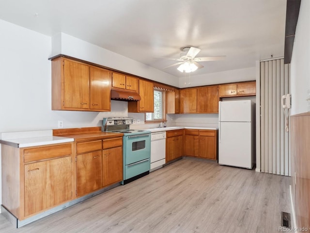 kitchen featuring ceiling fan, white appliances, sink, and light hardwood / wood-style flooring