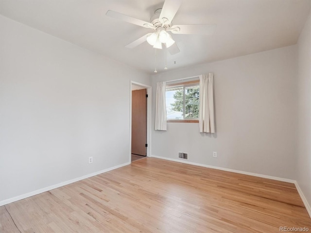 empty room with ceiling fan and light hardwood / wood-style floors