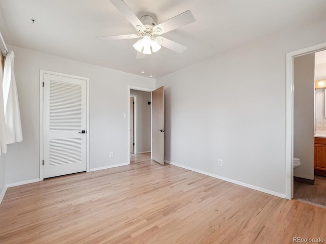 unfurnished bedroom featuring light wood-type flooring, a closet, ensuite bathroom, and ceiling fan