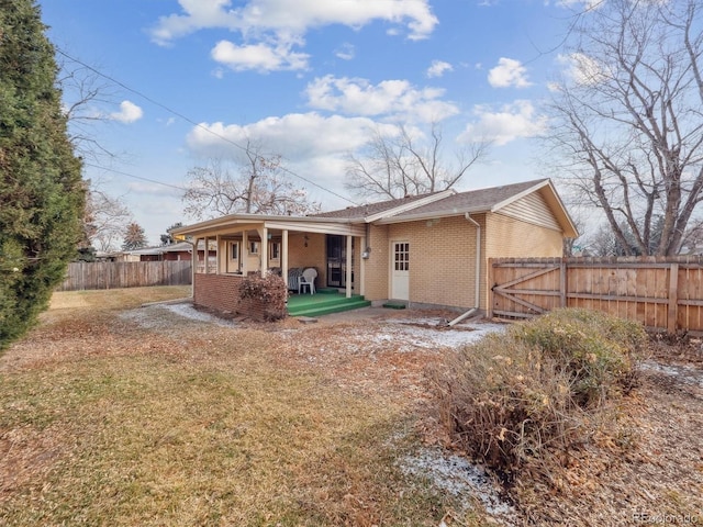 rear view of house with a yard and covered porch