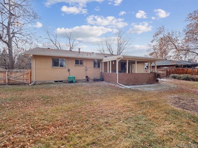 rear view of house with a sunroom and a lawn