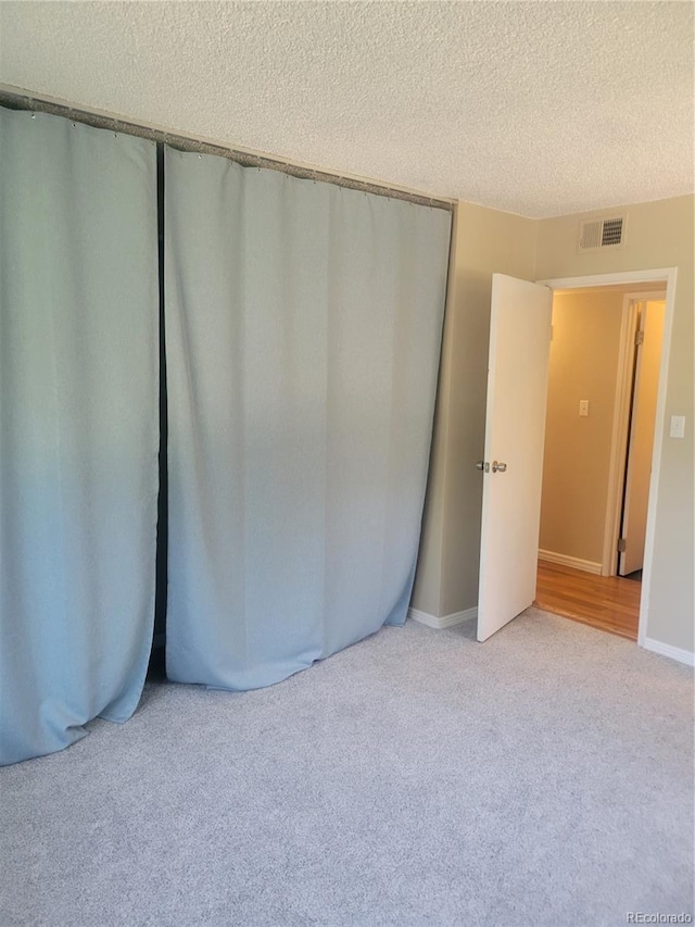 4400 S Quebec St Unit 108L, Denver, CO 80237 - unfurnished bedroom featuring carpet floors, a closet, and a textured ceiling