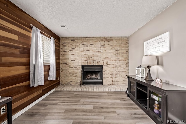 4416 E 93rd Pl, Thornton, CO 80229 - living room featuring a textured ceiling, a fireplace, wood finished floors, and wooden walls