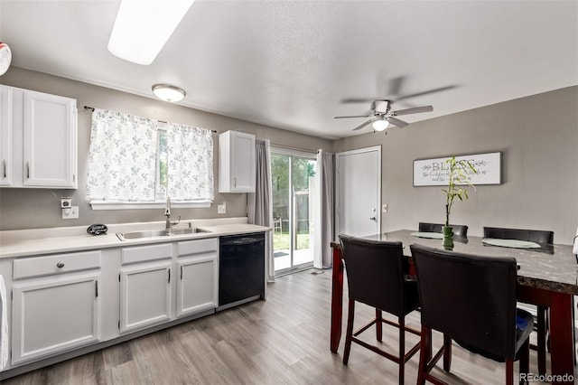4416 E 93rd Pl, Thornton, CO 80229 - kitchen featuring black dishwasher, white cabinets, ceiling fan, light wood-type flooring, and light countertops