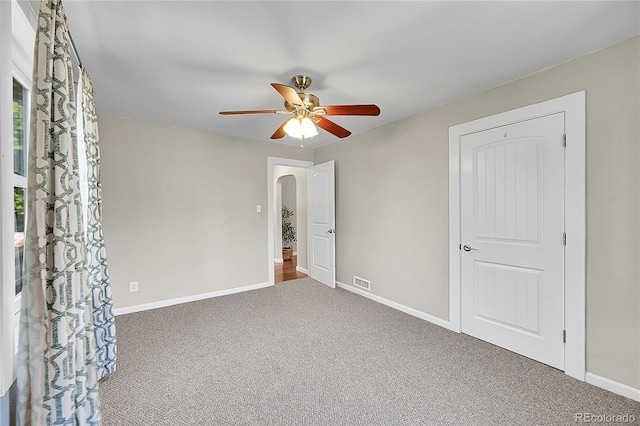 4268 S Delaware St, Englewood, CO 80110 - unfurnished bedroom with carpet flooring, arched walkways, and a ceiling fan