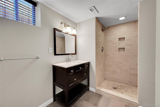 4268 S Delaware St, Englewood, CO 80110 - bathroom featuring vanity, tiled shower, and tile patterned flooring