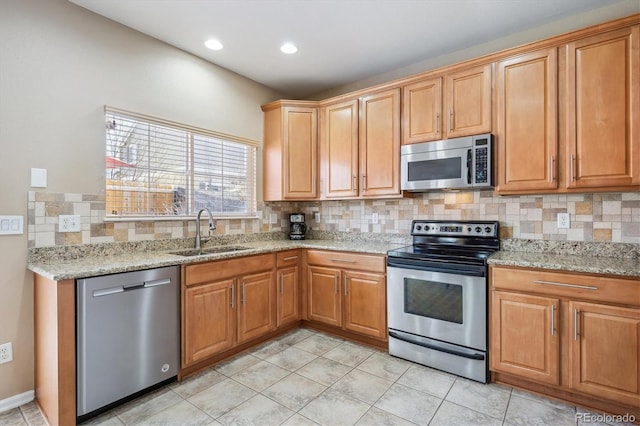 7342 S Mobile St, Aurora, CO 80016 - kitchen with stainless steel appliances, a sink, tasteful backsplash, light stone counters, and light tile patterned flooring