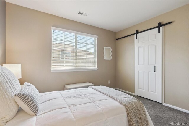 7342 S Mobile St, Aurora, CO 80016 - bedroom featuring a barn door, carpet flooring, and baseboards