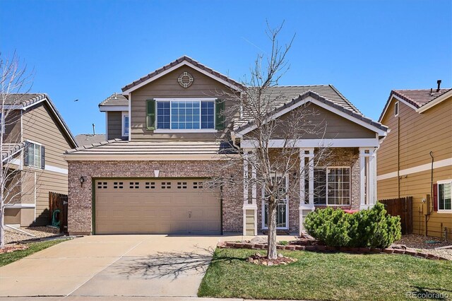 7342 S Mobile St, Aurora, CO 80016 - view of front of home with a tiled roof, brick siding, concrete driveway, and a garage