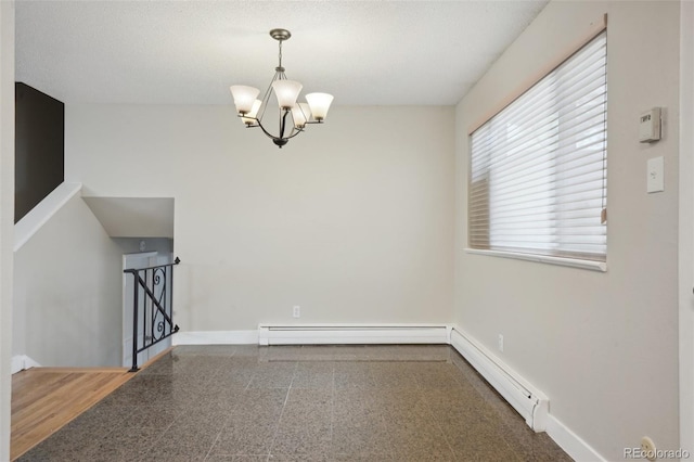 spare room with baseboard heating and a notable chandelier