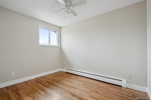 empty room featuring baseboard heating, ceiling fan, a textured ceiling, and hardwood / wood-style flooring