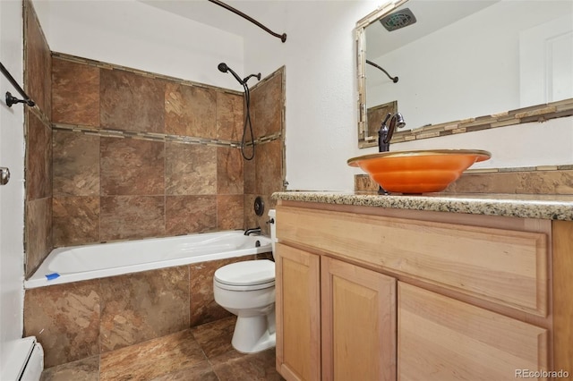 full bathroom with vanity, toilet, tiled shower / bath, and baseboard heating