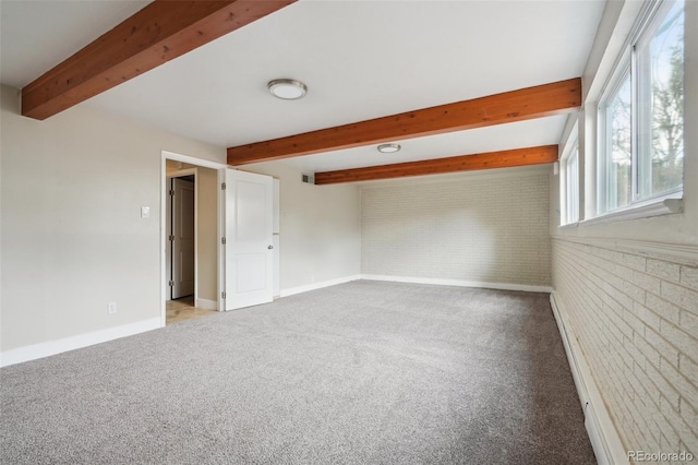 empty room featuring beamed ceiling, brick wall, and carpet flooring