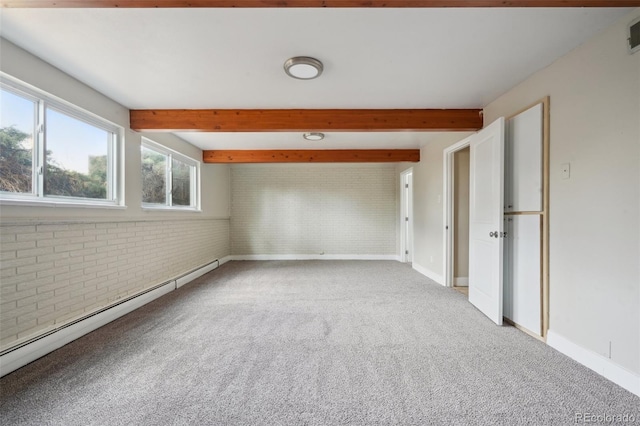 spare room with beamed ceiling, a baseboard radiator, brick wall, and light carpet