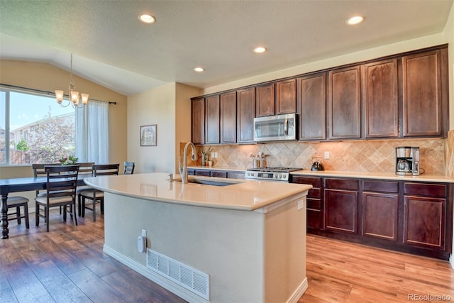 3470 Daydreamer Dr, Colorado Springs, CO 80908 - kitchen featuring stainless steel microwave, light wood-type flooring, light countertops, a chandelier, and tasteful backsplash