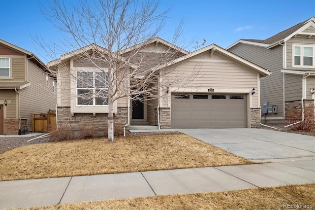 view of front of house featuring an attached garage, stone siding, and concrete driveway