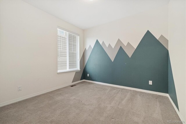 carpeted empty room with visible vents and baseboards