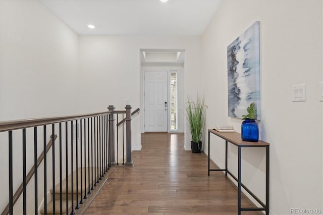 hallway with wood finished floors, an upstairs landing, and baseboards