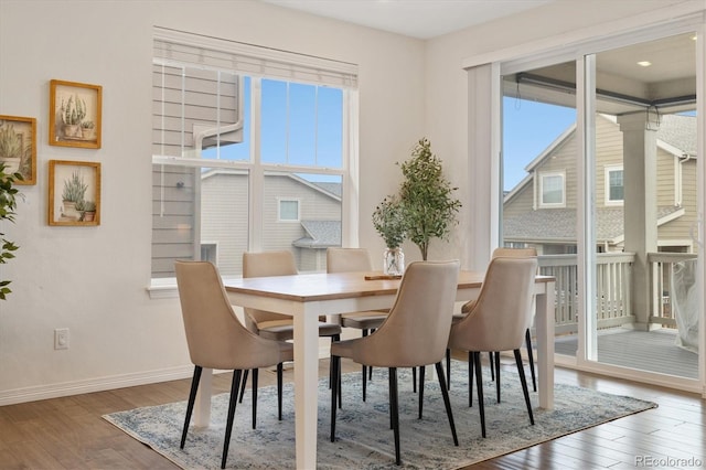 dining area featuring wood-type flooring and baseboards