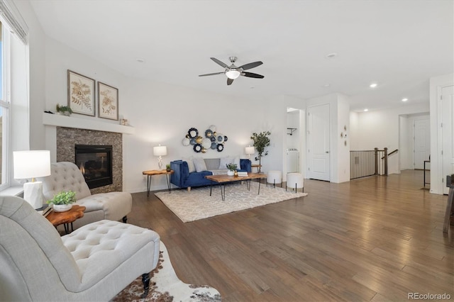 living area with a glass covered fireplace, ceiling fan, recessed lighting, and wood finished floors