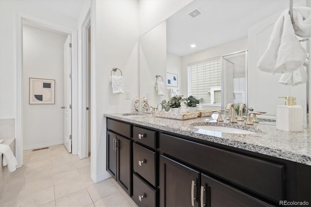 bathroom featuring tile patterned flooring, a sink, visible vents, a shower stall, and double vanity