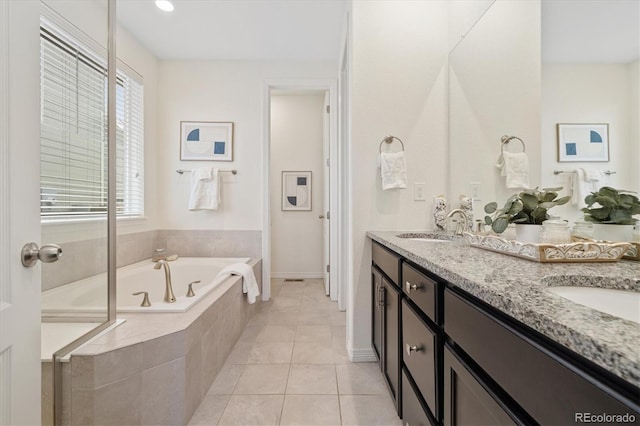 bathroom featuring double vanity, a sink, a bath, and tile patterned floors