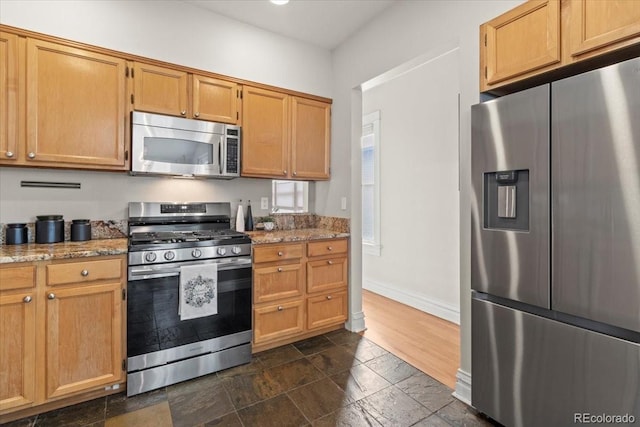 kitchen featuring light stone counters and stainless steel appliances