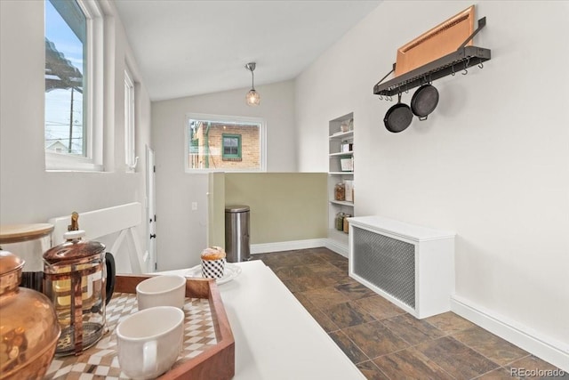 dining room with lofted ceiling and radiator