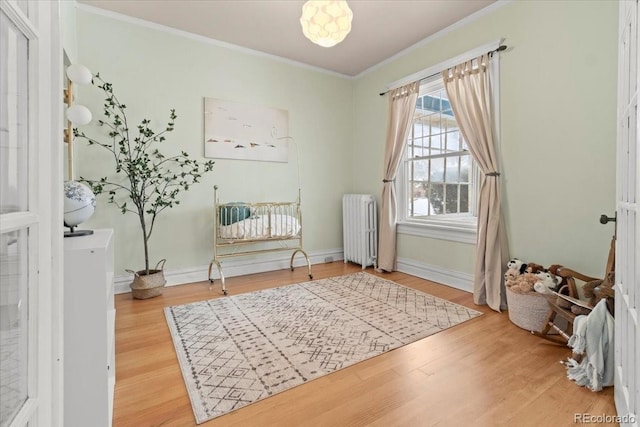 2377 Cherry St, Denver, CO 80207 - living area with radiator, ornamental molding, baseboards, and wood finished floors